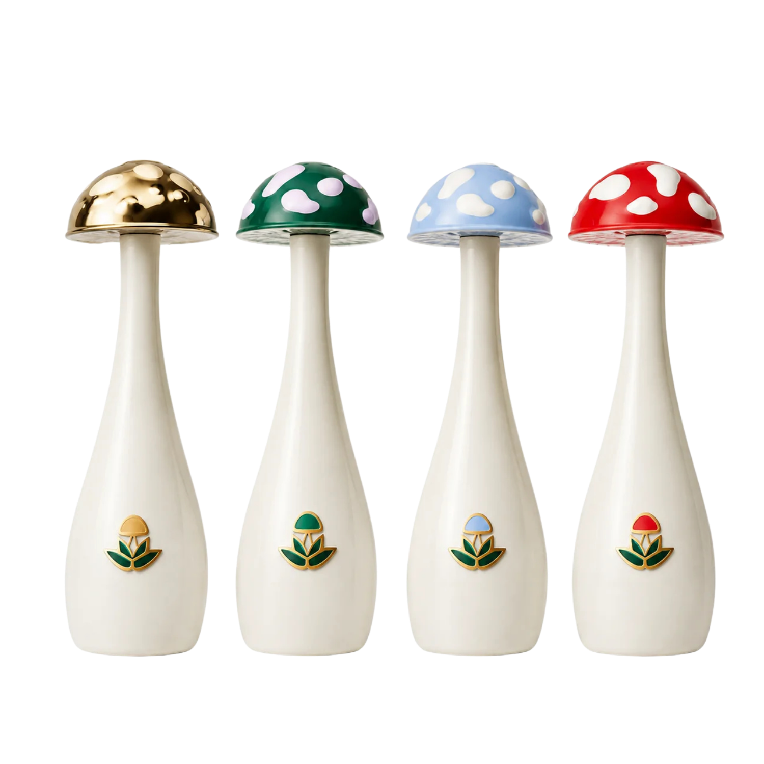 Four mushroom-shaped tequila by side on a white background. Each atomizer has a cream-colored body, a colorful mushroom cap (gold, green, light blue, and red with white spots), and a small matching floral emblem near the base.